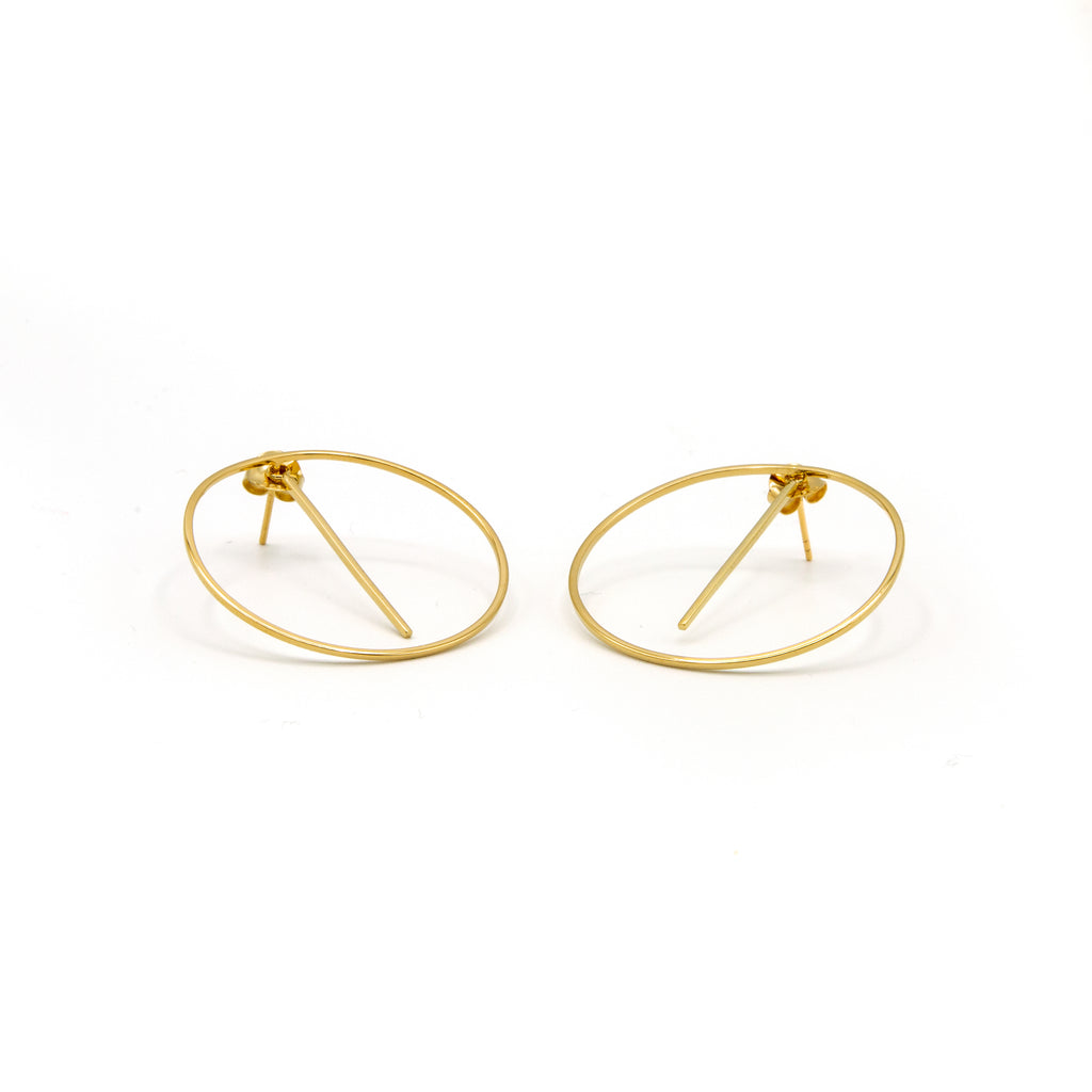 A pair of gold-colored hoop earrings with a circular design and small protruding rods at the bottom.